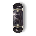 A Yurt fingerboard complete with silver trucks and white wheels, consisting of a 5-ply maple deck with a Real Wear graphic with a dark gothic design featuring four crows and the word 'Yurt' in a gothic font on the tail. The board has a black background with a detailed print of a skeletal crow under a cloudy sky.