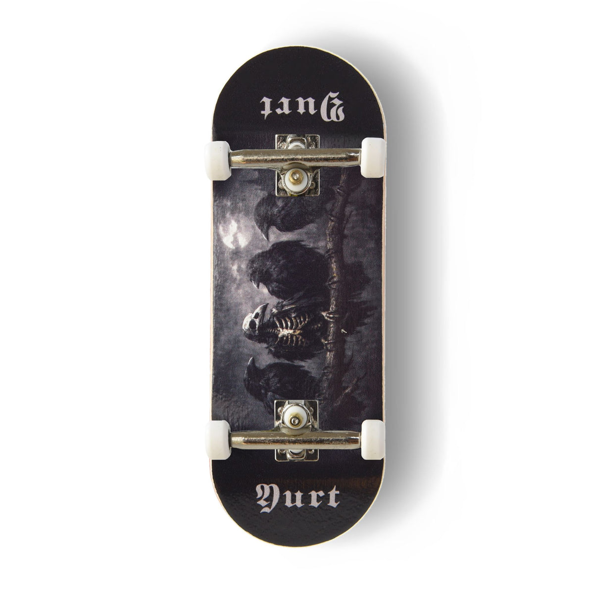 A Yurt fingerboard complete with silver trucks and white wheels, consisting of a 5-ply maple deck with a Real Wear graphic with a dark gothic design featuring four crows and the word 'Yurt' in a gothic font on the tail. The board has a black background with a detailed print of a skeletal crow under a cloudy sky.