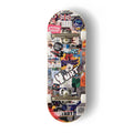 A Yurt fingerboard complete with silver trucks and white wheels, consisting of a 5-ply maple deck with a colourful Real Wear graphic design of a graffiti and flyer covered door against a clean white background.