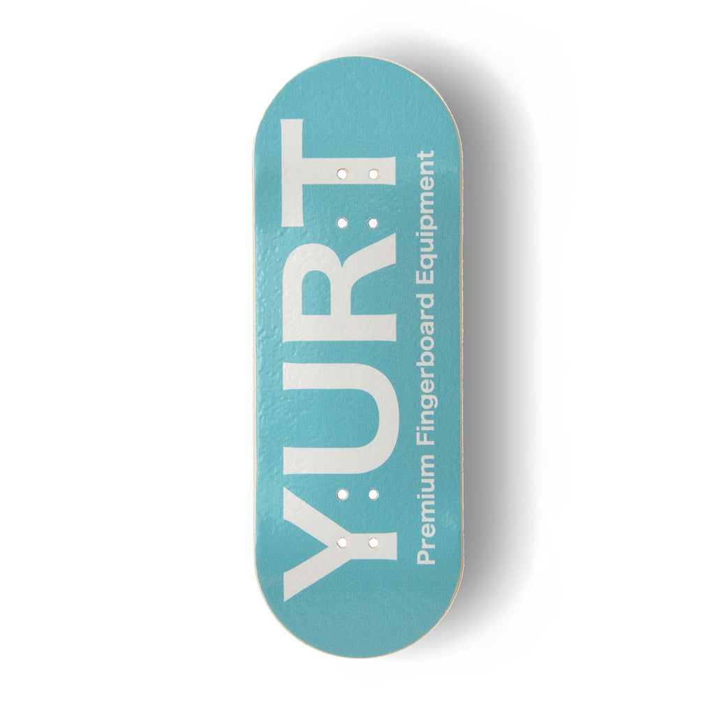 A Yurt fingerboard 5-ply maple deck with a Real Wear graphic featuring a turquoise fingerboard with the brand name 'YURT' printed in white. The fingerboard is photographed from a top-down perspective on a clean white background with a soft drop shadow.